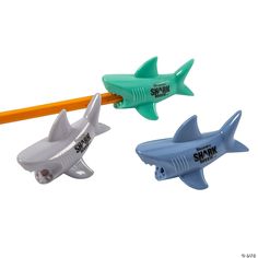 three plastic shark pencils in different colors