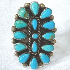 Vintage Zuni Petit Point Ring, Sterling Turquoise Cluster Ring, Needle Point Ring, Size 8 Ring, Old Pawn Native American Jewelry Large and dynamic vintage Zuni petit point cluster ring with bezel set turquoise petit point stones.  This unisex ring is a size 8 and the top of the ring is  1 1/2" x 1 ".  Not signed but tests sterling silver.  Wonderful vintage condition with no chips or damage to the stones. More Native American Jewelry https://www.etsy.com/shop/VintageVogueTreasure?ref=hdr&search_query=native+american More Southwestern Jewelry https://www.etsy.com/shop/VintageVogueTreasure?ref=hdr&search_query=southwestern Needle Point, Southwestern Jewelry, Unisex Ring, American Jewelry, Native American Jewelry, Cluster Ring, Turquoise Jewelry, Sterling Ring, Last Minute Gifts