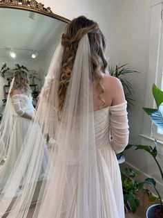 the bride is getting ready to walk down the aisle in her wedding dress and veil