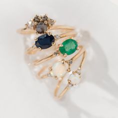 three rings with different colored stones on top of each other, one is gold and the other is white