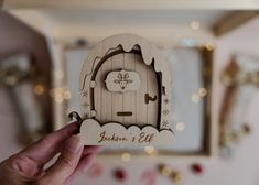 a person holding up a wooden cut out of a hobbot with the words luken's elf on it