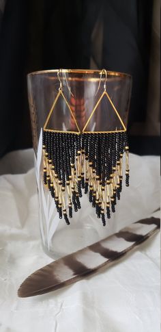 The romance between black and gold is timeless. Sparkling gold bugle beads shine brightly against a semi matte black backdrop. Pops of matte gold flank their boldness. Woven onto gold plated triangles and finished with 14k gold filled ear wires. Made to order. Black Beaded Earrings With Dangling Beads For Evening, Black Dangling Beads Earrings For Evening, Black Beaded Dangling Earrings For Evening, Gold Beaded Earrings With Dangling Beads For Evening, Handmade Gold Beaded Earrings For Evening, Gold Beaded Earrings With Black Beads As Gift, Elegant Black Beaded Earrings With Gold Beads, Black Beaded Drop Earrings With Gold Beads, Black And Gold Beaded Drop Earrings