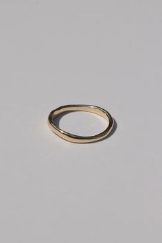 a gold ring on a white surface with no one in the photo to describe it