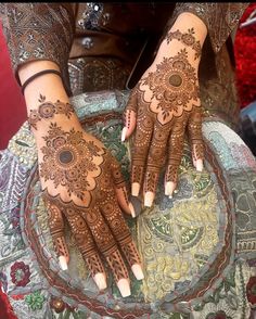 two hands with henna tattoos on them