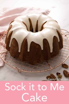 a bundt cake with icing and pecans on a wire rack