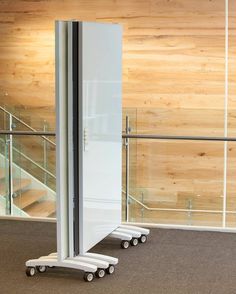 a room divider with wheels in front of a wooden wall and stairs behind it