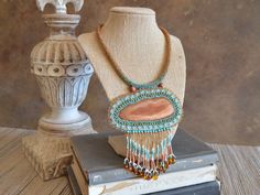 "One of a kind huge bead embroidery statement necklace / earthy Western feel / Artisan handmade dyed agate / beaded rope, beaded toggle You are sure to stand out in a room when you enter wearing this one of a kind statement necklace! Truly no one else will have it because there is only one and you've got it! Featured on this necklace is a focal pendant made of intricate bead embroidery surrounding a beautiful piece of sliced agate. Lots of different kinds of tiny beads. The fringe is made of mor Handmade Turquoise Agate Beaded Necklaces, Artisan Beaded Necklaces With Gemstone Beads, Artisan Gemstone Beaded Necklaces, Handmade Bohemian Beaded Pendant Necklaces, Bohemian Handmade Beaded Pendant Necklaces, Artisan Brown Handwoven Necklace, Handmade Adjustable Earthy Beaded Necklaces, Artisan Beaded Pendant, Brown Bohemian Beads For Crafting