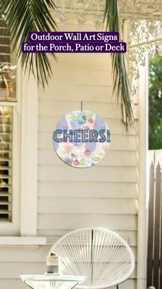 an outdoor wall art sign for the porch, patio or deck is shown above a chair and table