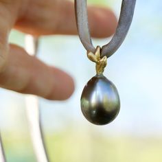 Gorgeous large grey Tahitian pearl set in 18 karat gold and strung on naturally dyed silk. There is no clasp so that you can wear it at any length, or around your wrist, or you can slide off the pendant and put it on your favourite chain. The total length of the drop pendant is 1 inch. The pearl measures approximately 12 x 16mm. Available for immediate shipping from Sweden. Delivery 1+2 weeks depending on your location. For free shipping select AIRMAIL at checkout. Elegant Luxury Tahitian Pearl Bracelets, Tahitian Pearl Pendant, Reflecting Light, Dyed Silk, Pearl Set, Tahitian Pearls, Silk Dyeing, Naturally Dyed, Drop Pendant