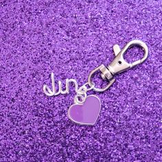 a purple heart shaped keychain with the word june written in silver on it