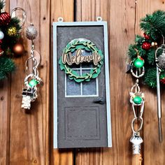 a christmas wreath and keychain hanging on a wooden wall next to some ornaments