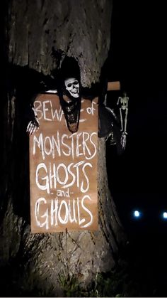 a sign that has been placed on a tree in the dark with a creepy face painted on it