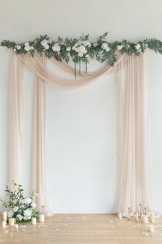 the wedding arch is decorated with flowers and greenery for an elegant touch to the room