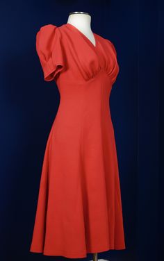 This dress is hand-made and is based on a 1940's sewing pattern. The dress features an empire waistline with draping under the bust, short puffy sleeves with small darts for extra shape, and a wide flared hemline that'll swirl beautifully as you dance. There is a zipper on the side. The material is a heavy viscose blend crepe in bright red or burnt orange. It has a beautiful heavy drape and movement. Dry cleaning is recommended for this dress. MEASUREMENTS PLEASE READ CAREFULLY BEFORE PURCHASING Elegant Fitted Vintage Dress In Solid Color, Solid Color Dresses With Lined Fitted Bodice, Elegant Solid Color Fitted Vintage Dress, Fitted Cocktail Dresses With Gathered Neckline, Vintage Dress With Fitted Bodice And Sweetheart Neckline, Fitted Dress With Gathered Neckline, Midi Dress With Pleated Bodice, Solid Dress With Fitted Bodice And Flattering Silhouette, Vintage A-line Cocktail Dress With Fitted Bodice