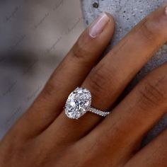 a woman's hand with a diamond ring on her finger and an engagement band