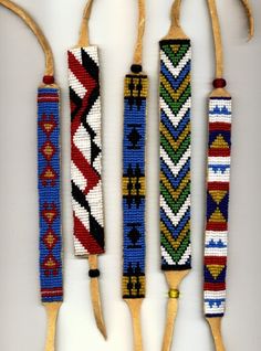 four different types of beaded items hanging from wooden hooks on a wall with rope