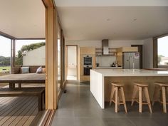 an open kitchen and dining area with wooden stools