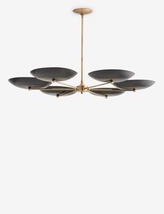 a modern chandelier with five black plates hanging from it's brass frame