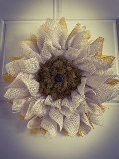 a white and gold sunflower on a door with burlap around the center