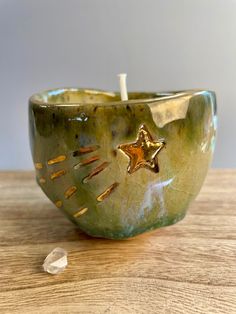 a green candle holder with a gold star on it