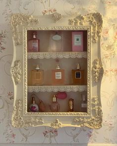 a white shelf filled with lots of different types of perfumes on top of it