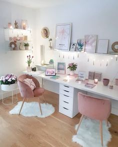 a white desk with pink chairs and pictures on the wall above it in a bedroom