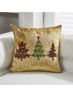 a gold christmas tree pillow on a white couch