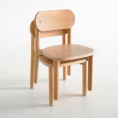 a wooden chair sitting on top of a white floor next to another chair that is made out of wood