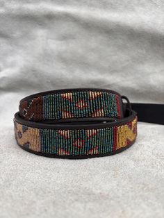 The Belts are made from ethically sourced leather in Kenya. The collars are then hand beaded by Maasai women artisans from my Village in Kajiado who have mastered the art. The hardware is made from 100% recycled brass. TO MEASURE CORRECTLY If you know your pants waist size, you can follow the add-two-inches rule i.e if your pants waist measurement is 32 Inches, then your belt size will be 34-36 Inch Belt. Our measurements are from the tip of the Buckle of the Belt to the second hole after the be Artisan Multicolor Fabric Belt, Adjustable Artisan Multicolor Belt, Traditional Adjustable Brown Belt Buckles, Adjustable Brown Traditional Belt Buckles, Handmade Multicolor Belt For Festivals, Handmade Multicolor Belts For Festival, Artisan Adjustable Fabric Belt, Southwestern Adjustable Embroidered Belt, Artisan Brown Embroidered Belt