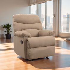 a beige recliner chair sitting on top of a hard wood floor next to a window