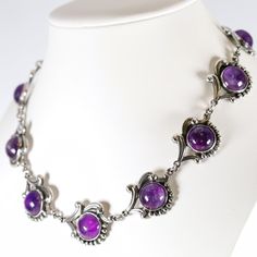 "Los Castillo Amethyst Necklace | Sterling Silver Vintage Jewelry | Mid-Century Taxco Mexico Crafted from sterling silver and featuring amethyst cabochons, this necklace showcases the exceptional artistry of the esteemed Los Castillo Taxco workshop. It consists of eleven panels, each graced with a nicely matched amethyst cabochon, making up a 14.5\" necklace that exudes timeless artistry. Marked with the Los Castillo hallmark dating from 1950 to 1965, this exquisite and highly coveted piece is a must-addition for collectors with discerning tastes. PRODUCT SPECIFICATION Product Type: Vintage  Maker: Los Castillo          Hallmarks: Los Castillo and Taxco encircling Eagle 15 Mexican assayer's mark, Made in Mexico and Sterling in a circle (1950-1965), 695 Materials: 925 Sterling Silver Gem or Elegant Amethyst Jewelry With Sterling Silver Clasp, Formal Amethyst Jewelry With Polished Finish, Classic Amethyst Cabochon Jewelry, Elegant Polished Amethyst Necklace, Elegant Amethyst Necklace With Polished Finish, Formal Amethyst Necklace With Polished Finish, Elegant Purple Jewelry With Polished Finish, Elegant Purple Cabochon Jewelry, Formal Purple Jewelry With Polished Finish