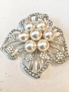 Elegant Silver Pearl Brooches, Glamorous Silver Brooch For Wedding, White Pearl Brooches For Formal Occasions, Formal White Pearl Brooches, Elegant Crystal-embellished Brooches For Weddings, Elegant Crystal-embellished Wedding Brooches, Elegant Crystal Embellished Brooches For Wedding, White Pearl Brooches For Party, Elegant Pearl Brooches For Party