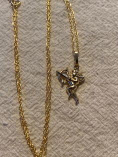 Cupid pendant in 14kt yellow gold. Measures about 1" including bail. Hangs from an 18" gold filled chain . Love the Cupid with his arrow! Weighs .81 gms. Vintage never worn brand new Vintage Gold Plated Tarnish Resistant Charm Necklace, Vintage Gold-plated Tarnish-resistant Charm Necklaces, Vintage Gold-plated Tarnish-resistant Charm Necklace, 14k Yellow Gold Jewelry With Large Pendant, 14k White Gold Jewelry With Large Pendant, 14k Gold Large Pendant Jewelry Gift, 14k Gold Jewelry With Large Pendant For Gift, Vintage Yellow Gold Tarnish Resistant Charm Necklaces, Vintage Tarnish Resistant Yellow Gold Charm Necklaces