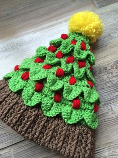 a crocheted christmas tree hat on top of a wooden floor