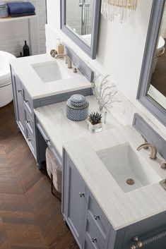 a bathroom with two sinks and a large mirror above the sink is decorated in blue and white