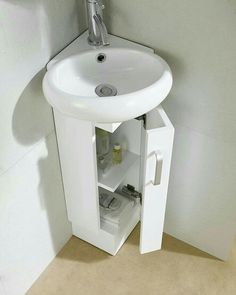 a white sink sitting under a bathroom mirror