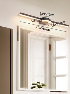 a bathroom mirror that has a plant in it and measurements on the wall above it