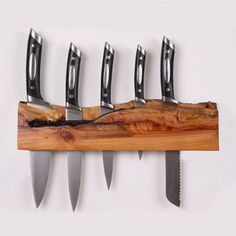 five knives are hanging on a wooden rack