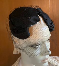 Classic and stylish 1950s crescent hat is crafted of quality textured black fabric. Full face veil adds allure and mystique. Sweet vintage rhinestones provide subtle sparkle to both hat and veil pieces. Instantly snazz up a solid black dress or suit with this lovely retro accessory piece One size fits all circa 1950s Headpiece will be carefully wrapped and placed into a secure box for shipping For more fabulous finds Please visit our boutique https://www.etsy.com/shop/chicvintageclassics?ref=hdr Retro Fascinator For Kentucky Derby Evening, Retro Evening Fascinator For Kentucky Derby, Retro Fascinator For Evening At Kentucky Derby, Vintage Evening Fascinator Headband, Vintage Cloche Headpieces For Evening, Vintage Adjustable Fascinator For Evening, Vintage Evening Headband Headpiece, Vintage Black Fascinator For Wedding, Vintage Headband Headpiece For Evening