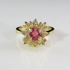 A beautiful precious earth mined pink sapphire and fine white diamond engagement ring dating to the mid century era crafted in 14K yellow gold. This classic ring designed as a ballerina style cluster setting is of heirloom quality. The beautiful pink sapphire itself has a unique pink color with just a hint of violet. The color is soft and feminine but definitely not ice cream it's more like the most exquisite dusty rose you could imagine. It weighs 5 grams. Currently it is a size 6 to 6 1/8 US. Pink Cluster Diamond Ring Fine Jewelry, Exquisite Pink Diamond Ring With Accent Stones, Exquisite Pink Round Diamond Ring, Pink Brilliant Cut Sapphire Ring In Fine Jewelry Style, Pink Brilliant Cut Sapphire Ring Fine Jewelry, Pink Diamond Ruby Ring With Brilliant Cut, Pink Ruby Ring With Brilliant Cut Diamond, Pink Cluster Diamond Ring, Pink Cluster Diamond Ring With Center Stone