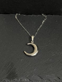 Crescent moon necklace hangs on stainless steel chain approx 18" Nickel Free Half Moon Silver Necklace, Nickel-free Silver Half Moon Necklace, Nickel-free Silver Half-moon Necklace, Moon Phase Metal Necklace In Moon Shape, Moon Phase Necklace In Metal, Metal Moon Phase Necklace, Metal Necklace With Moon Charm, Silver Half Moon Charm Necklaces, Silver Half Moon Charm Necklace