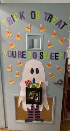 a door decorated to look like a ghost with candy in its hand and the words trick or treat you're so sweet written on it