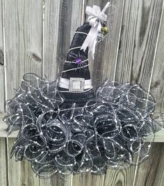 a black witch hat with silver sequins on it and a white ribbon around the top