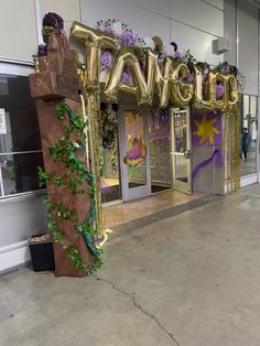 an entrance to a store decorated with giant balloons and greenery for the holiday season