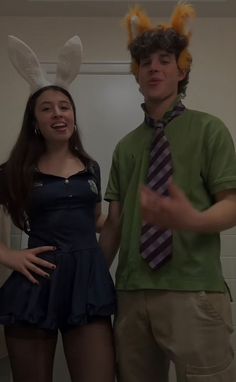 a man and woman dressed up in bunny ears standing next to each other with their hands on their hips