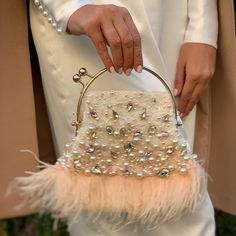 Vintage-looking light ivory bridal bag is handmade and decorated with a golden top handle, sparkling pinkish rhinestones, crystals, pearl beads, and coral ostrich feathers. The feathered clucth can contain all of the needed stuff on the ceremony. The tiny fancy bridal purse will be a great addition to your amazing look on the Special Day! The small elegant framed evening bag will be a lovely accessory not only for the bride but also will suit the bridesmaids' outfit, Mother of the bride, or Moth Elegant Evening Bags With Feathers, Pink Evening Bag With Pearl Handle For Party, Cream Handheld Clutch For Party, Elegant Bags With Feather Trim For Events, Cream Clutch Evening Bag For Party, Pink Evening Bag With Pearl Handle, Embellished Cream Evening Bag For Party, Glamorous Beige Evening Bag For Weddings, Bridal Handbag