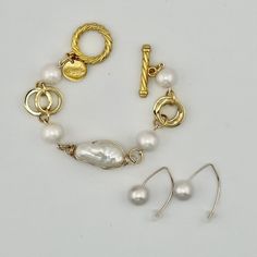 Center focal pearl is a freshwater baroque pearl wrapped in anti-tarnish gold wire. Each pearl will be unique in size and shape. Center pearl will be larger than the side pearls on the bracelet. All are genuine freshwater pearls. Easy toggle clasp. This is the gold version of the bracelet Susan wears in many of her posts on the blog from SusanAfter60, including her Being Cautious Post. As a size reference...If your wrist measures 6" you will need an 8" bracelet. Great complement for our PEARL LARIAT or PEARL EARRING. Shop the same bracelet in SILVER see it HERE Shop the Wishbone Wire (last photo) Earrings HERE At the time I made the video, only silver was available. See it layered in last photo with the Pearl Leather Cuff Bracelet. Shop with confidence.Love it or return it.We want you to l Adjustable Oyster Bracelet With Baroque Pearls, Adjustable Baroque Pearl Bracelet With Oyster Detail, Adjustable Baroque Pearl Bracelet With Pearl Drop, Adjustable Baroque Pearl Drop Bracelets, Gold Metal Pearl Bracelet With Pearl Charm, Gold Pearl Bracelet With Metal Charm, Adjustable Baroque Pearl Bracelet, Elegant Wire Wrapped Pearl Bracelet, Gold Baroque Pearl Bracelet With Pendant