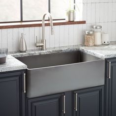 a stainless steel sink in a kitchen with granite counter tops