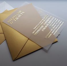 three envelopes are stacked on top of each other, with gold foil and white paper