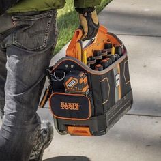 a man is holding a tool bag and skateboard